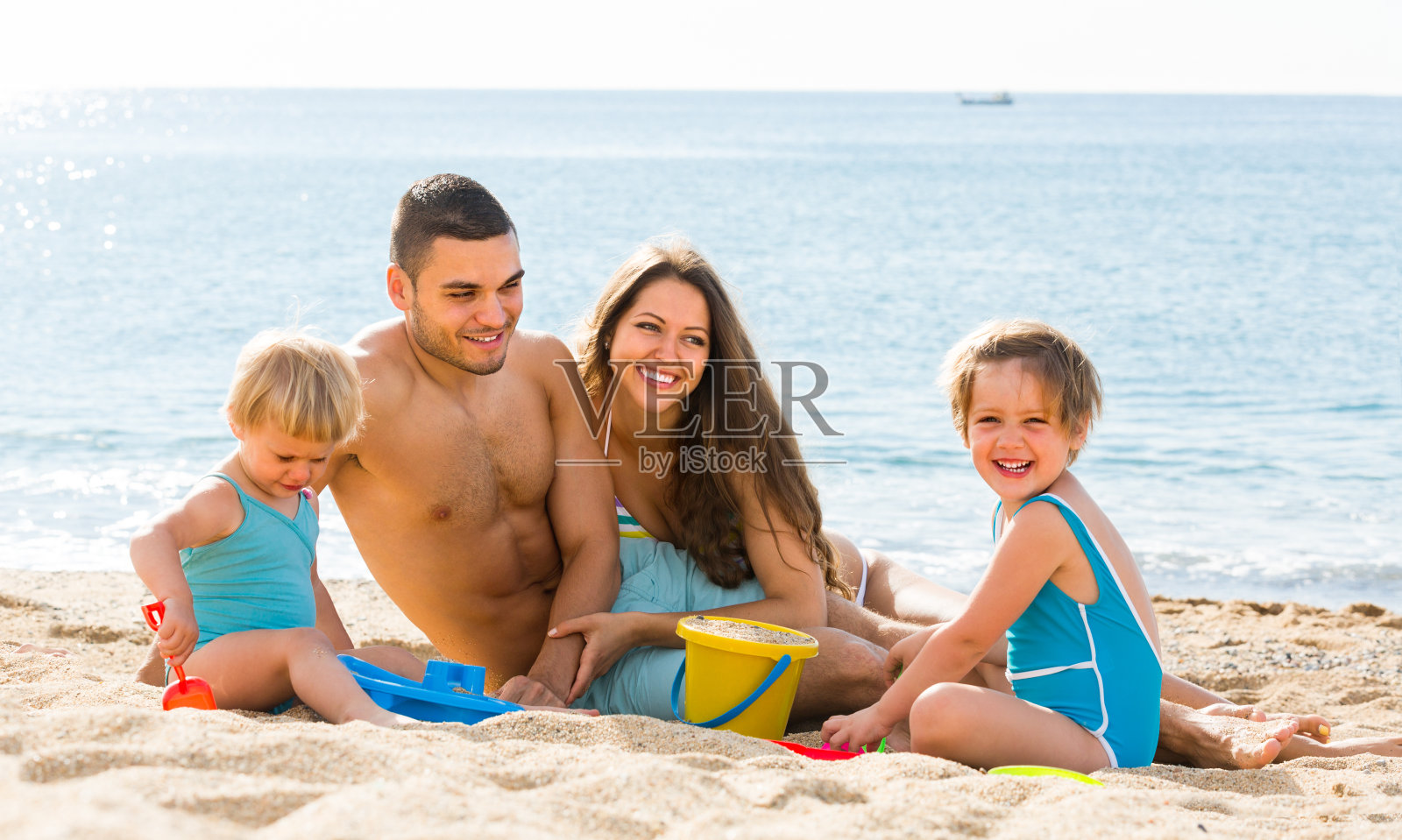 海滩上的一家四口照片摄影图片