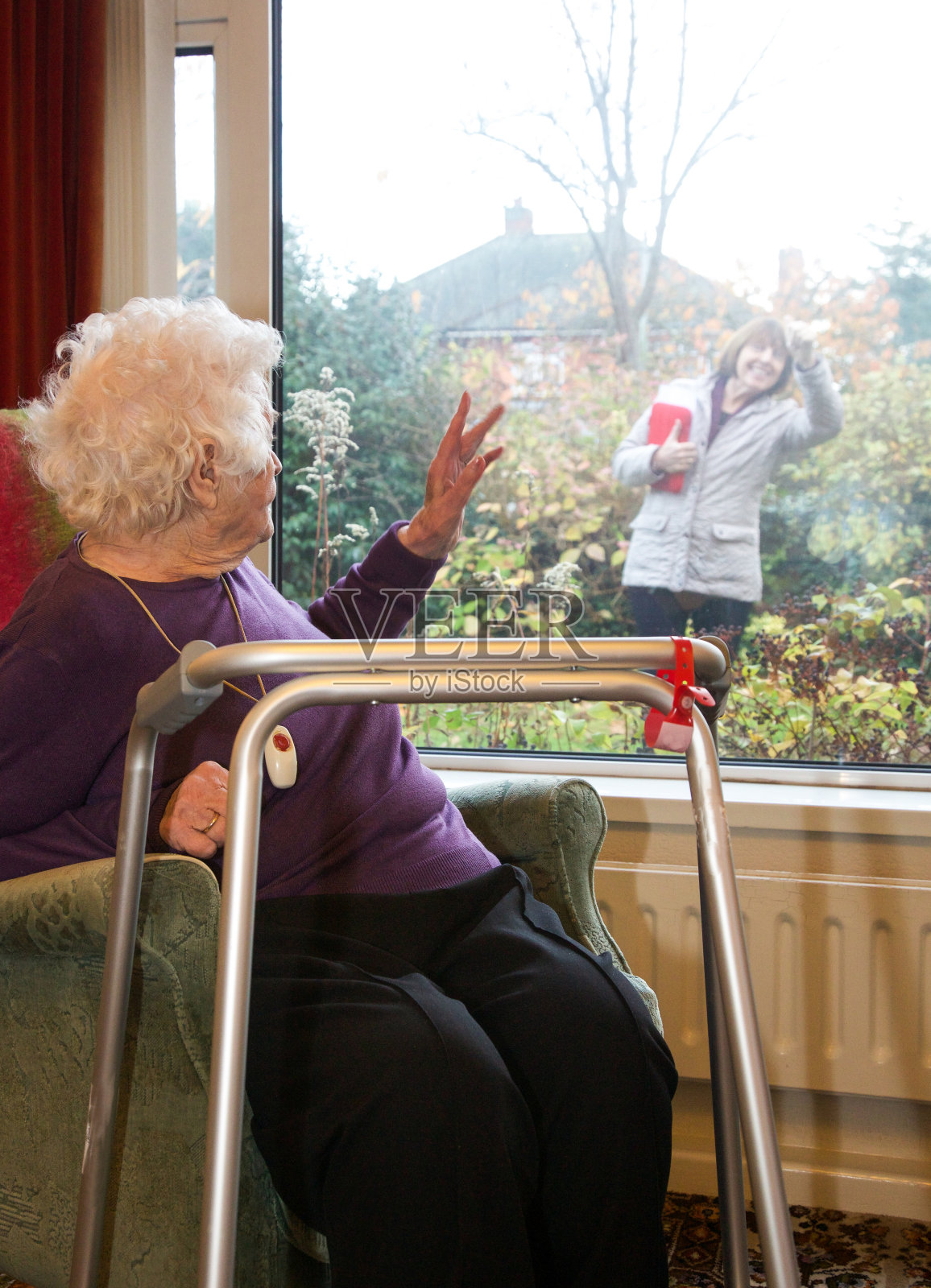 独立生活的老年客户挥手告别她的专业护理人员。照片摄影图片