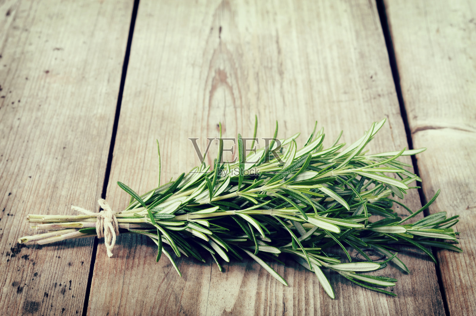 木桌上放一束新鲜的迷迭香。照片摄影图片