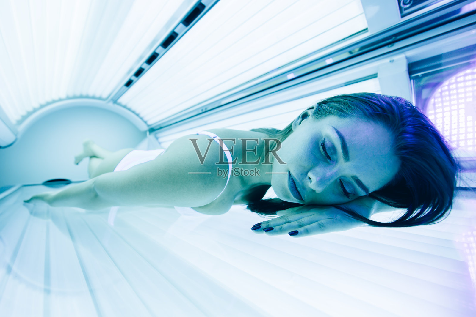 美丽的女人躺在日光浴室里照片摄影图片