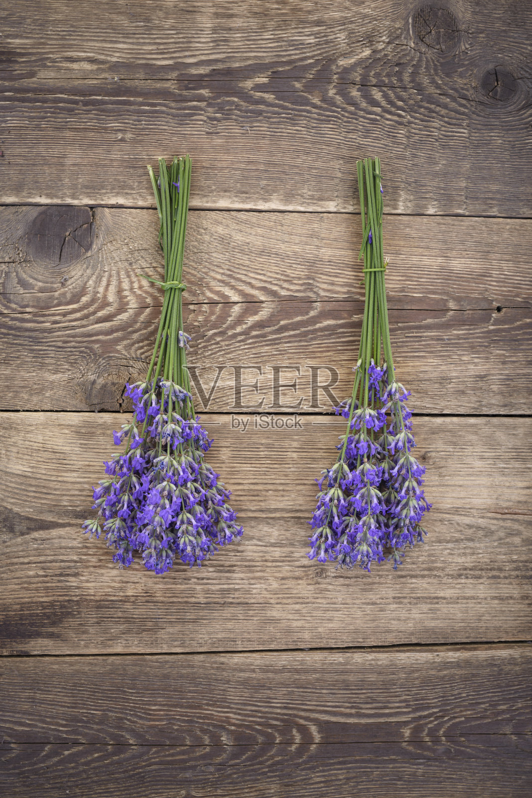 在质朴的木制背景上放着几束薰衣草照片摄影图片