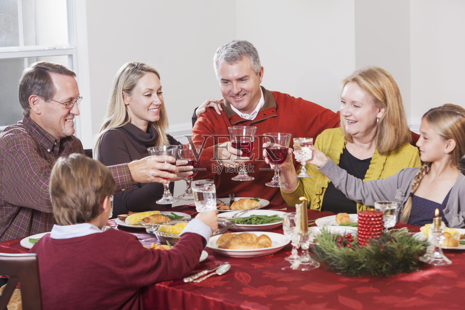 几代同堂的一家人共进晚餐，用烤面包庆祝照片摄影图片