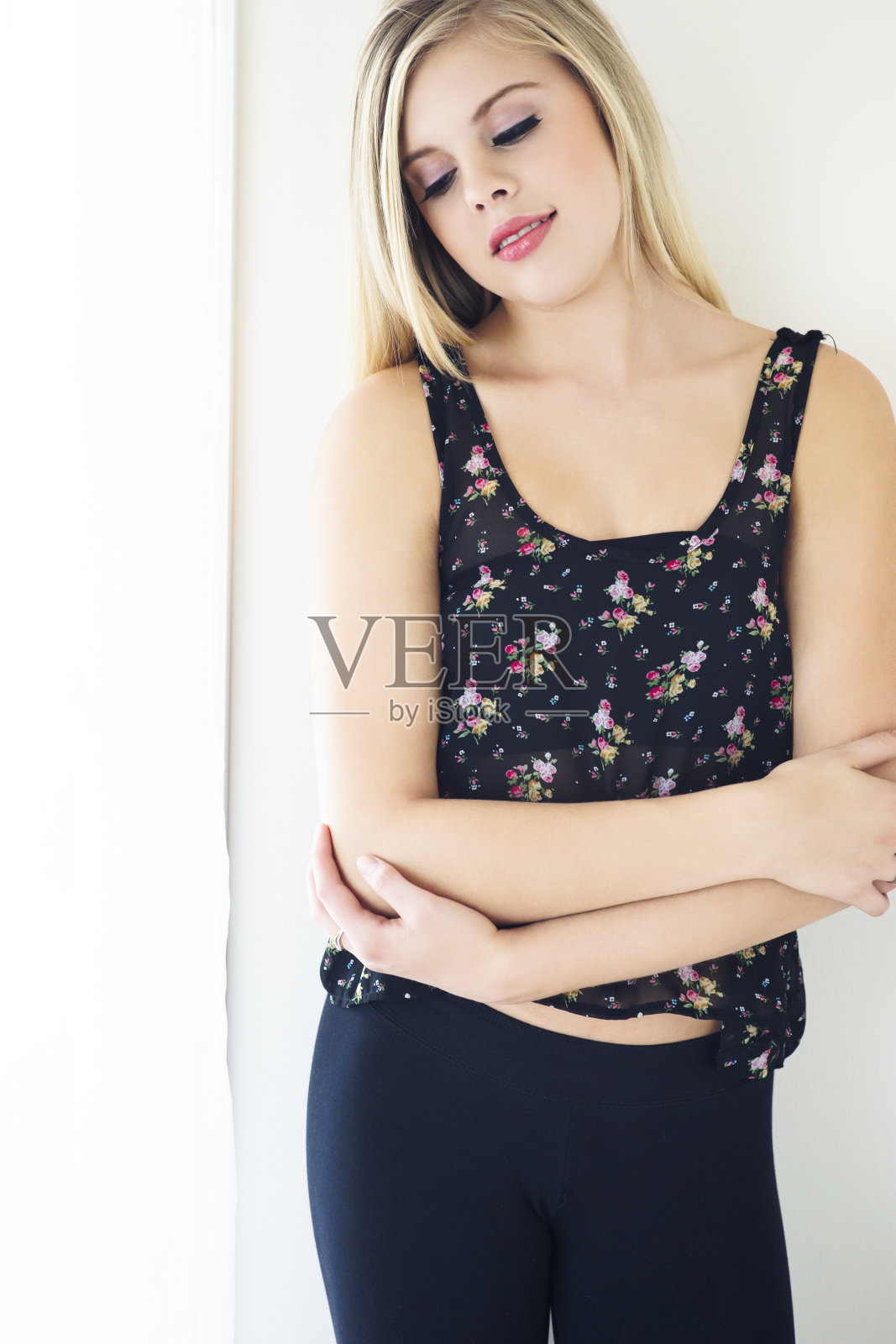 年轻漂亮的模特双臂交叉站在墙前照片摄影图片