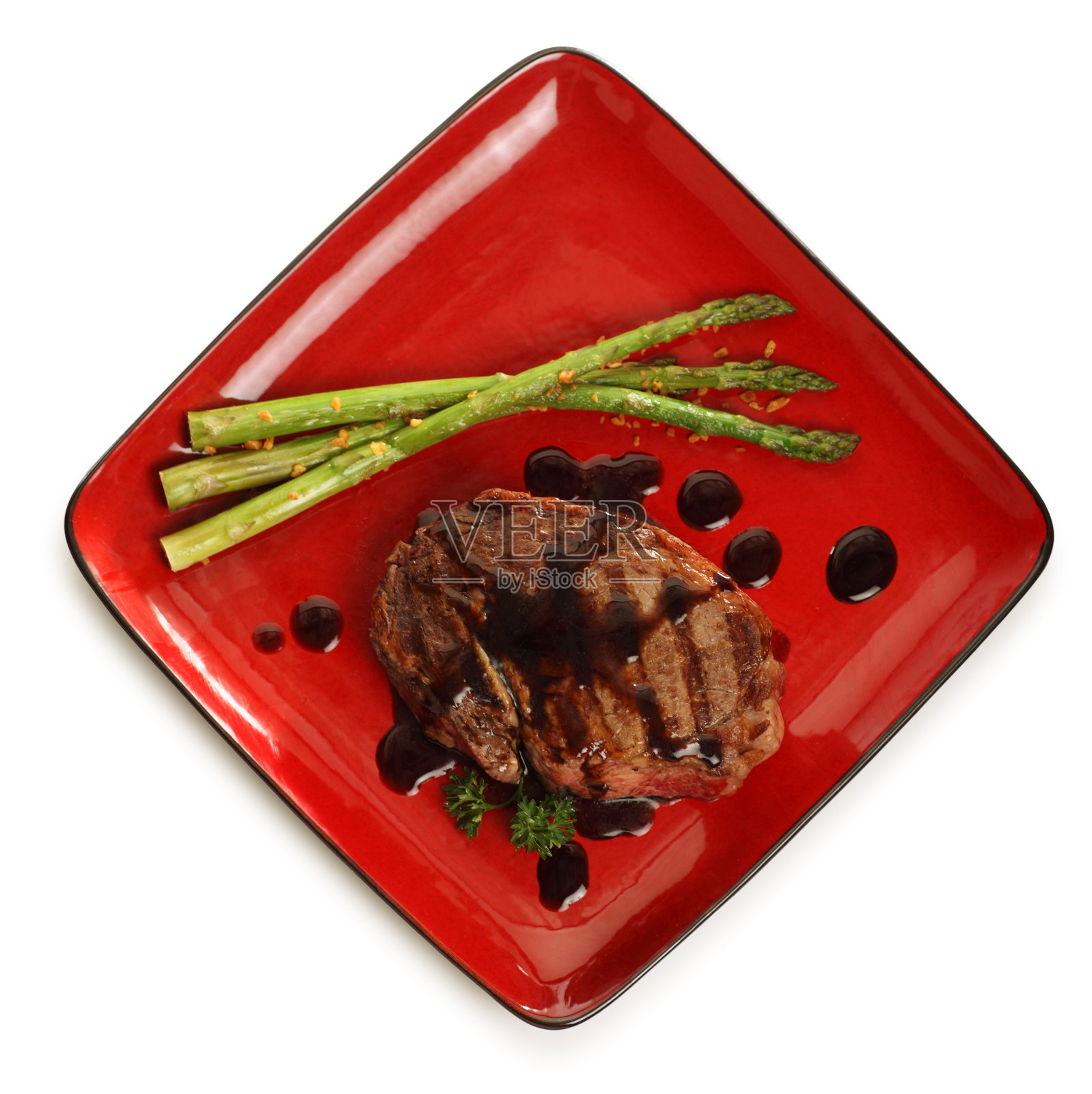 头顶上的牛排在一个红色的盘子照片摄影图片