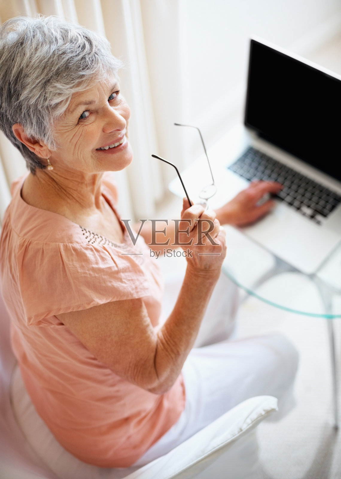 快乐的老奶奶用笔记本电脑给你一个微笑照片摄影图片