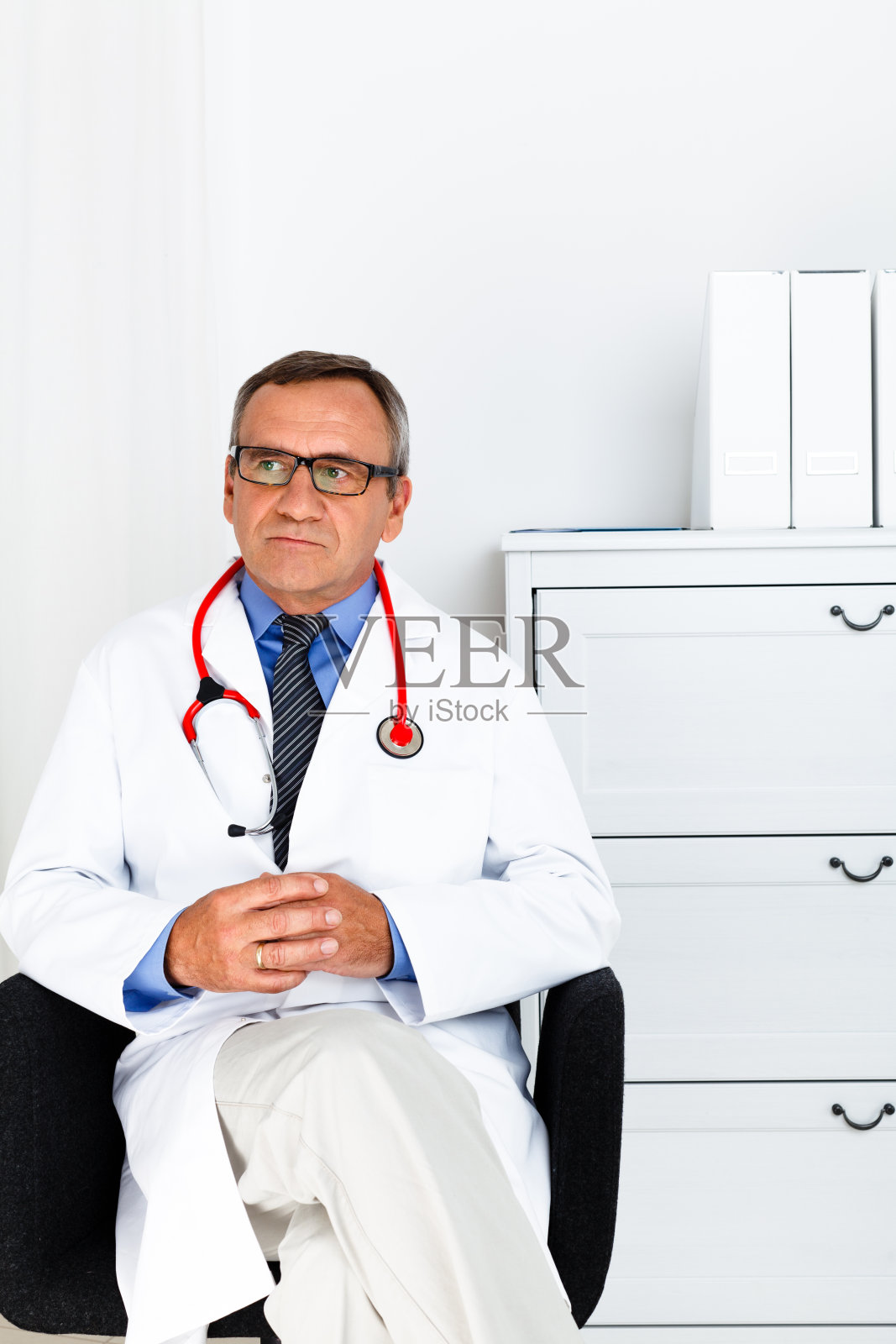 沉思的医生在白大褂，工作室拍摄照片摄影图片