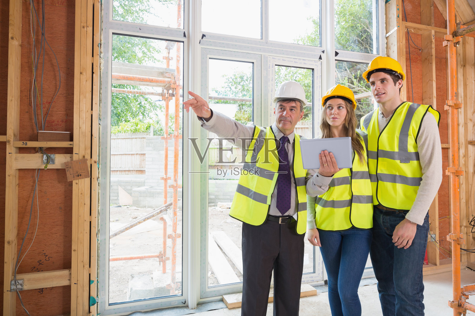 建筑师向穿着安全装备的夫妇指出了一些事情照片摄影图片