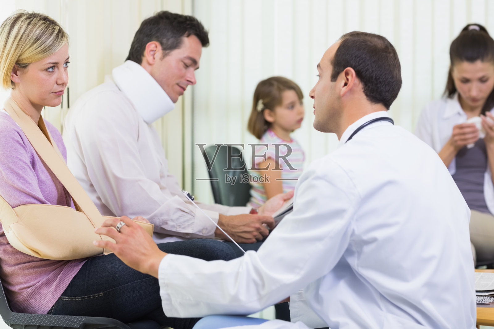 一个受伤的女人在候诊室和医生说话照片摄影图片