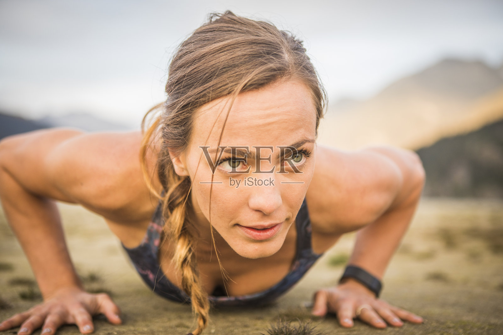 年轻女子在外面做俯卧撑。照片摄影图片