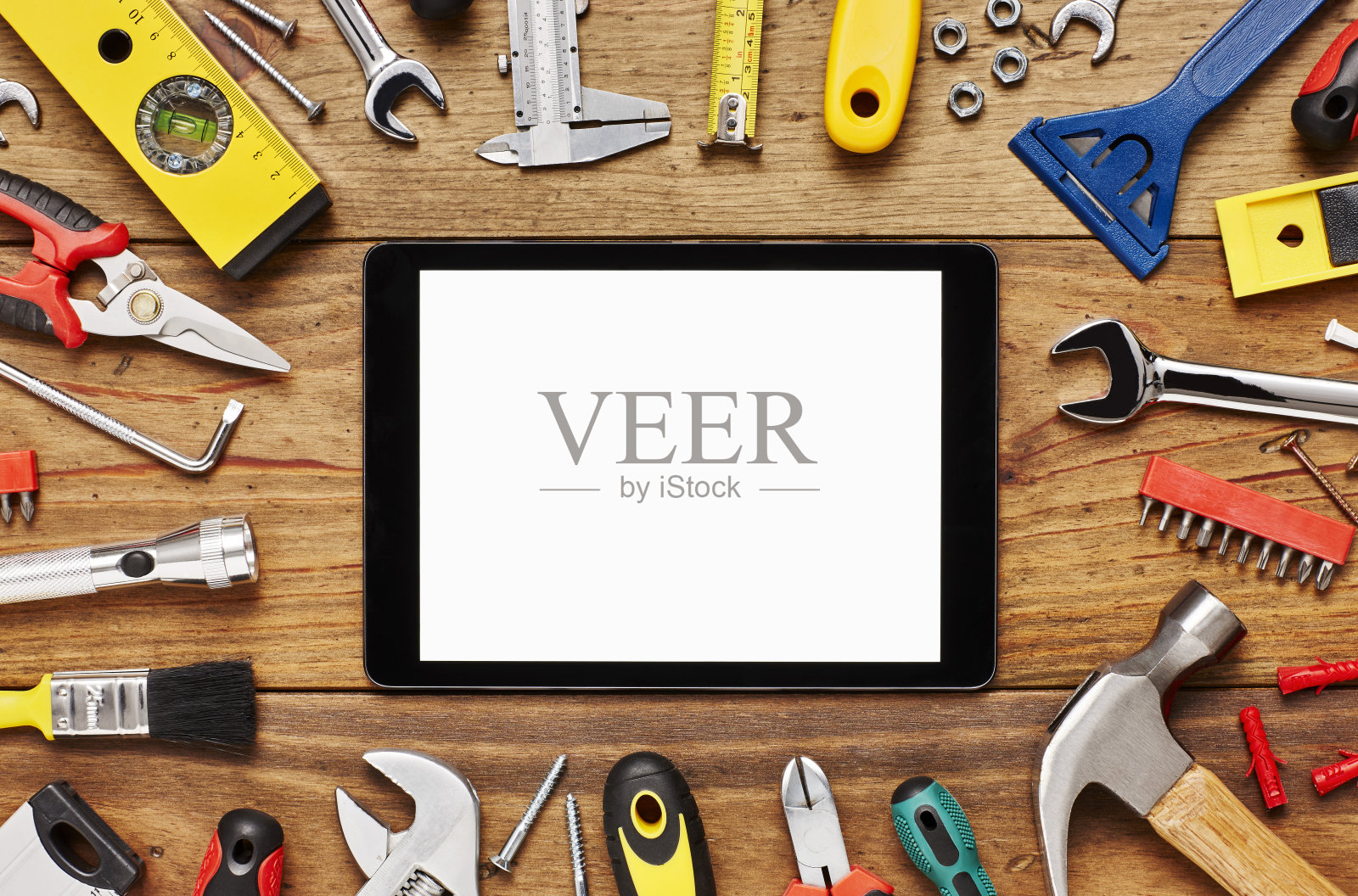 数字平板周围的各种施工工具在桌子上照片摄影图片