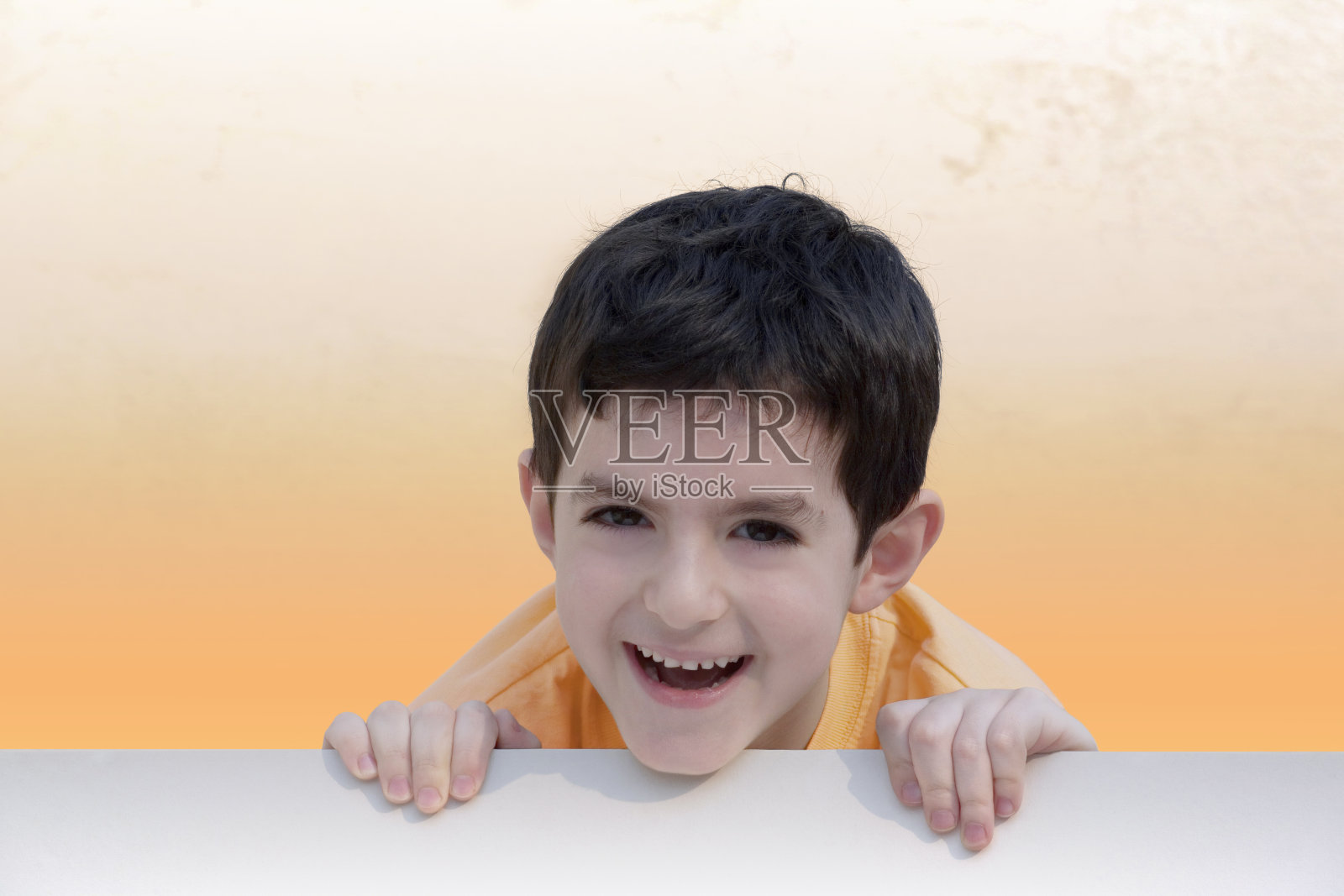 男孩在空白的广告牌后面笑照片摄影图片