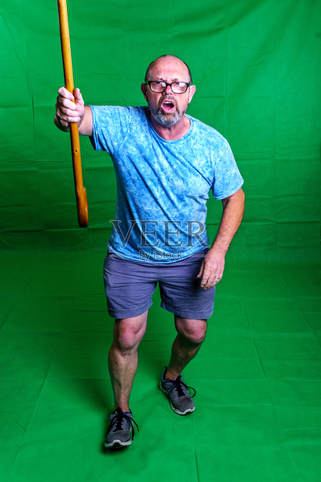 成熟的男人挥舞着手杖照片摄影图片