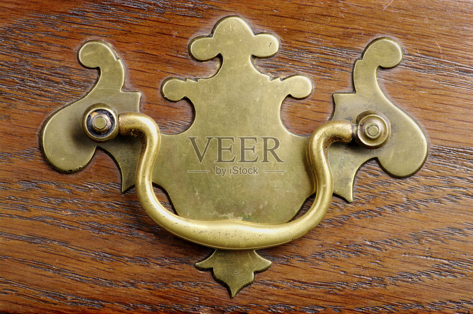 单一古董黄铜拉在橡木抽屉前面照片摄影图片