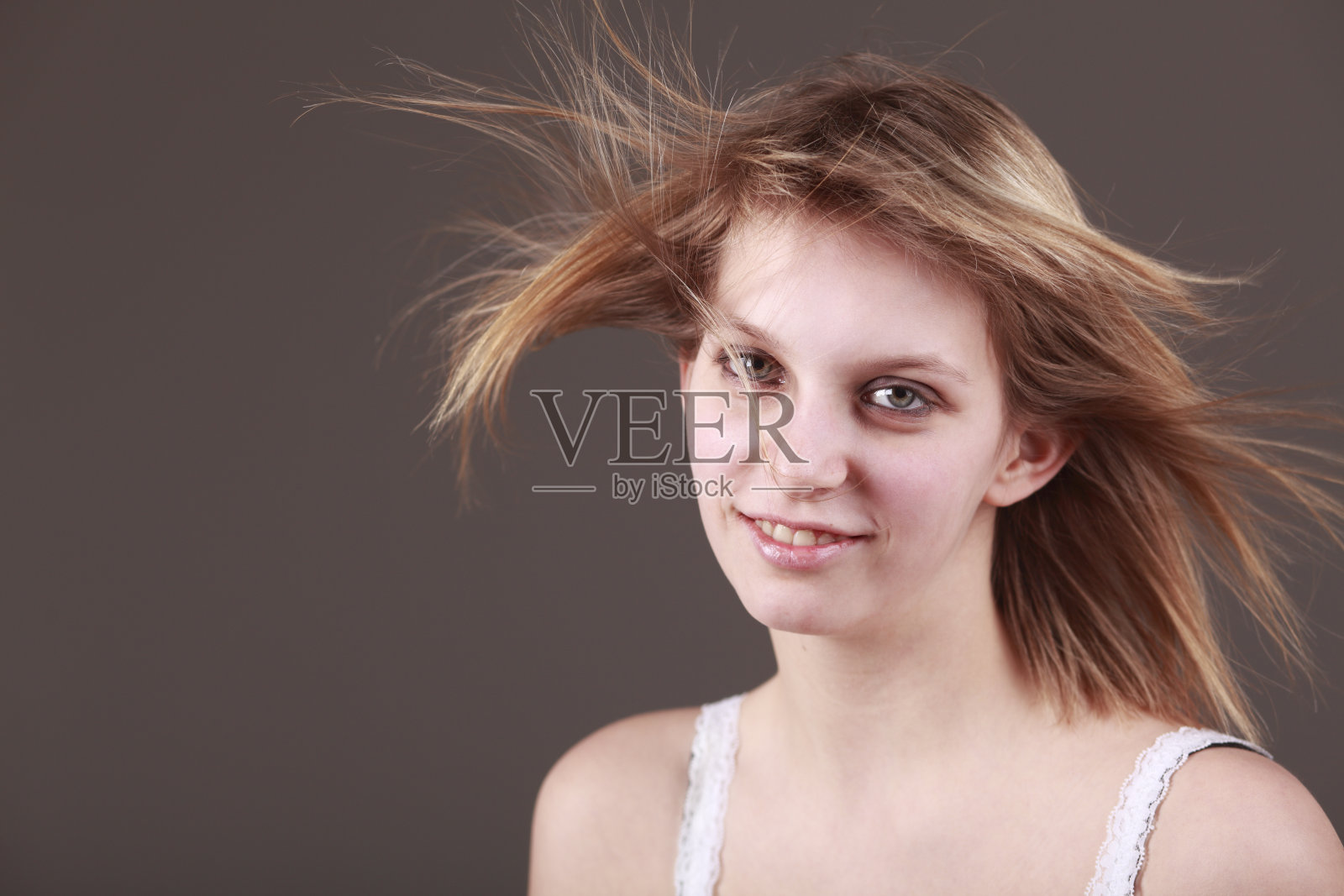 年轻的女人，风吹过她的头发照片摄影图片