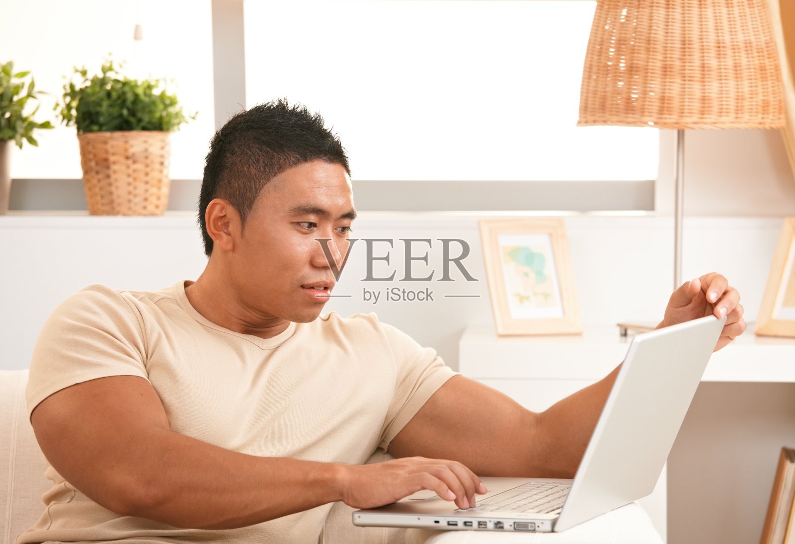 年轻的亚洲男子在家里浏览互联网照片摄影图片