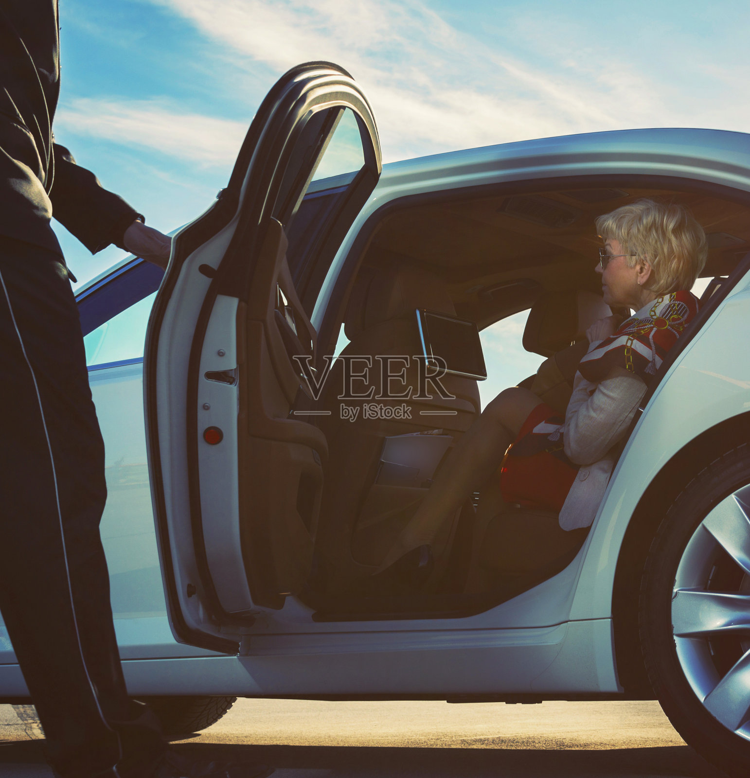 豪华轿车司机在机场帮助一位老妇人照片摄影图片