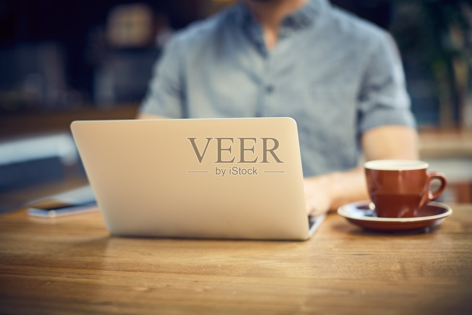 在咖啡厅里使用笔记本电脑的时髦年轻人的腹部照片摄影图片