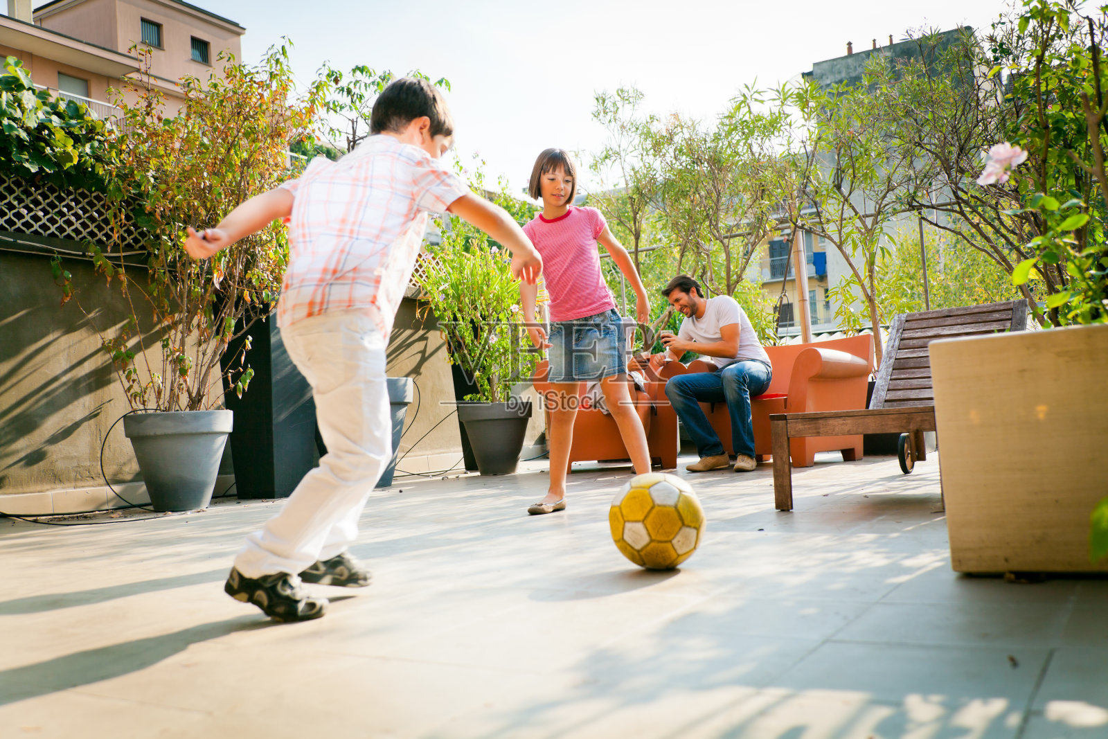 一家人在自家后院踢足球照片摄影图片