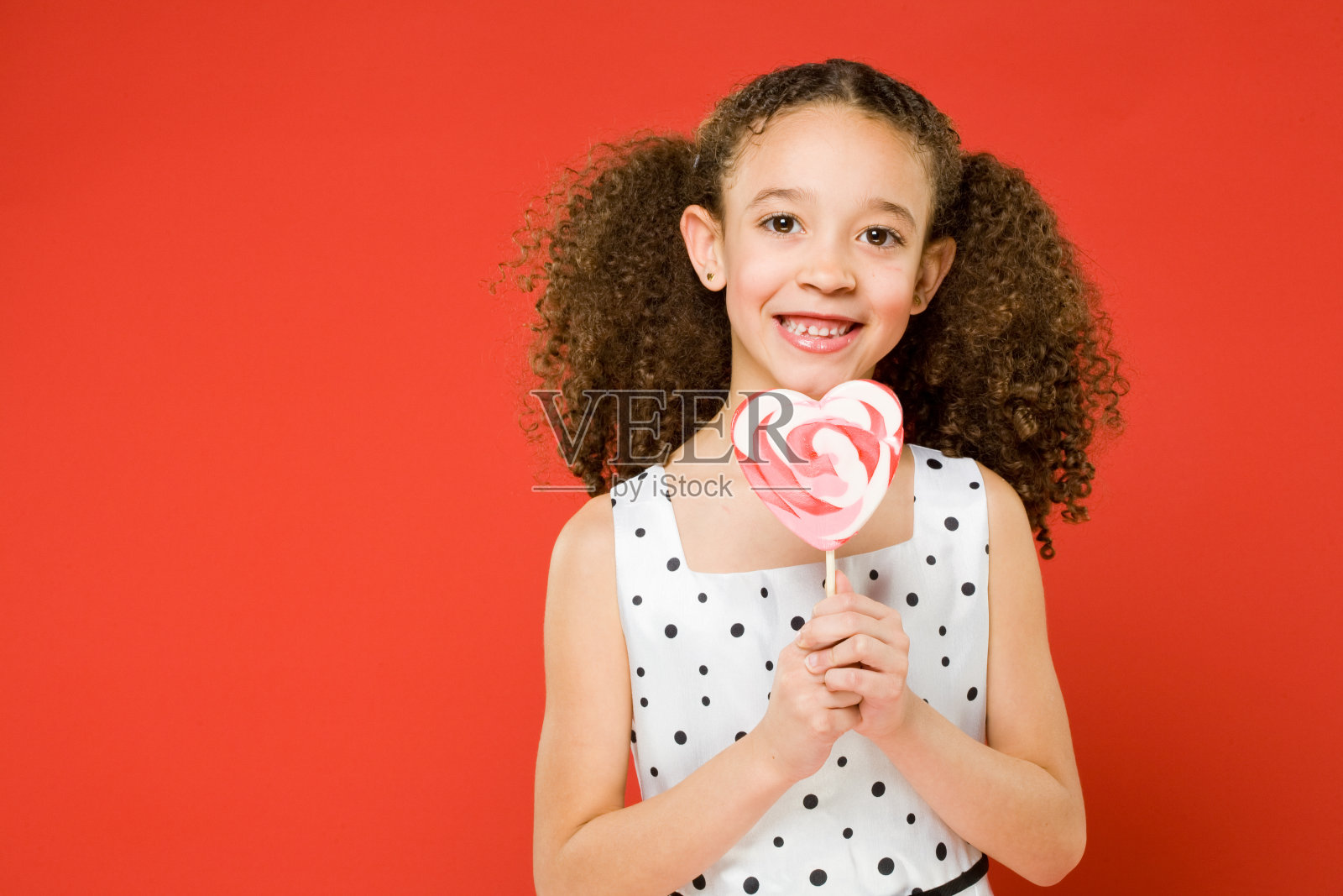 快乐的小女孩拿着棒棒糖照片摄影图片