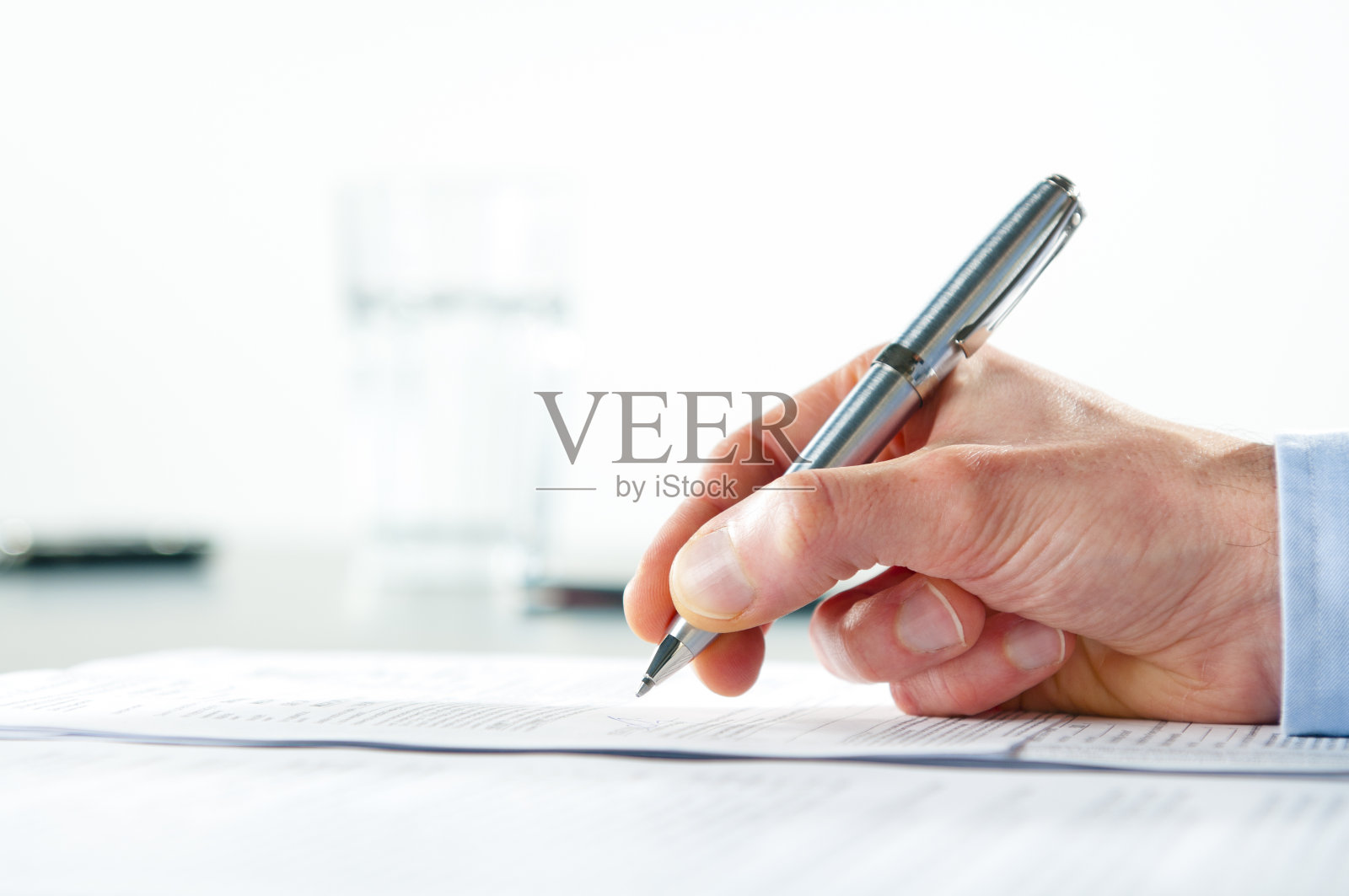 手握银笔签署文件照片摄影图片