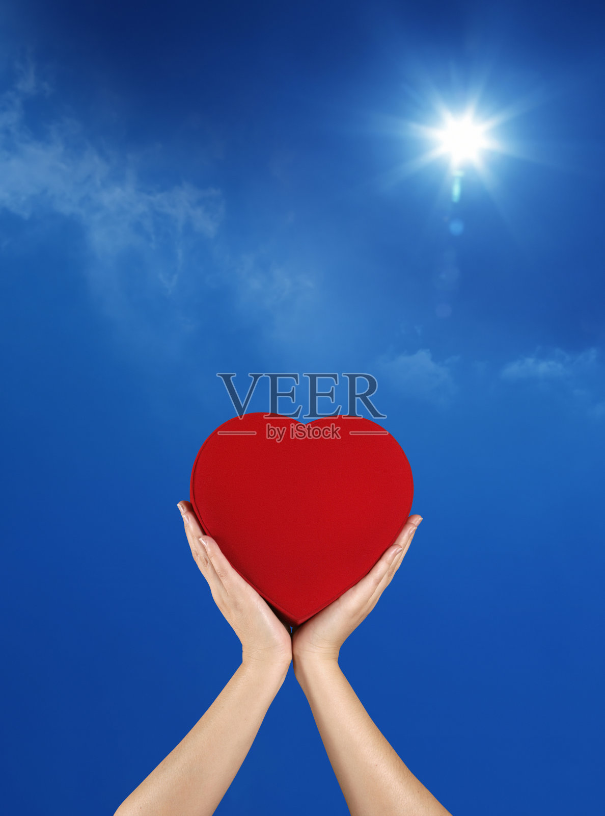 捧着红心越过晴朗的天空照片摄影图片