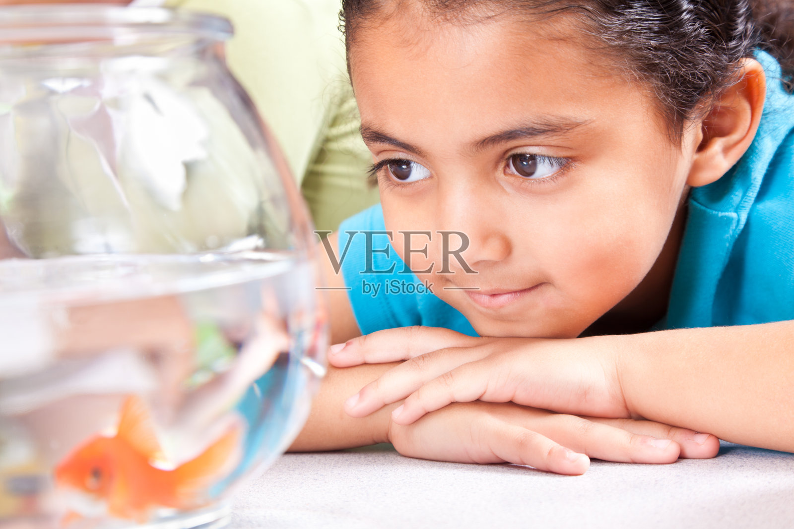 可爱的小女孩在学校教室看金鱼照片摄影图片