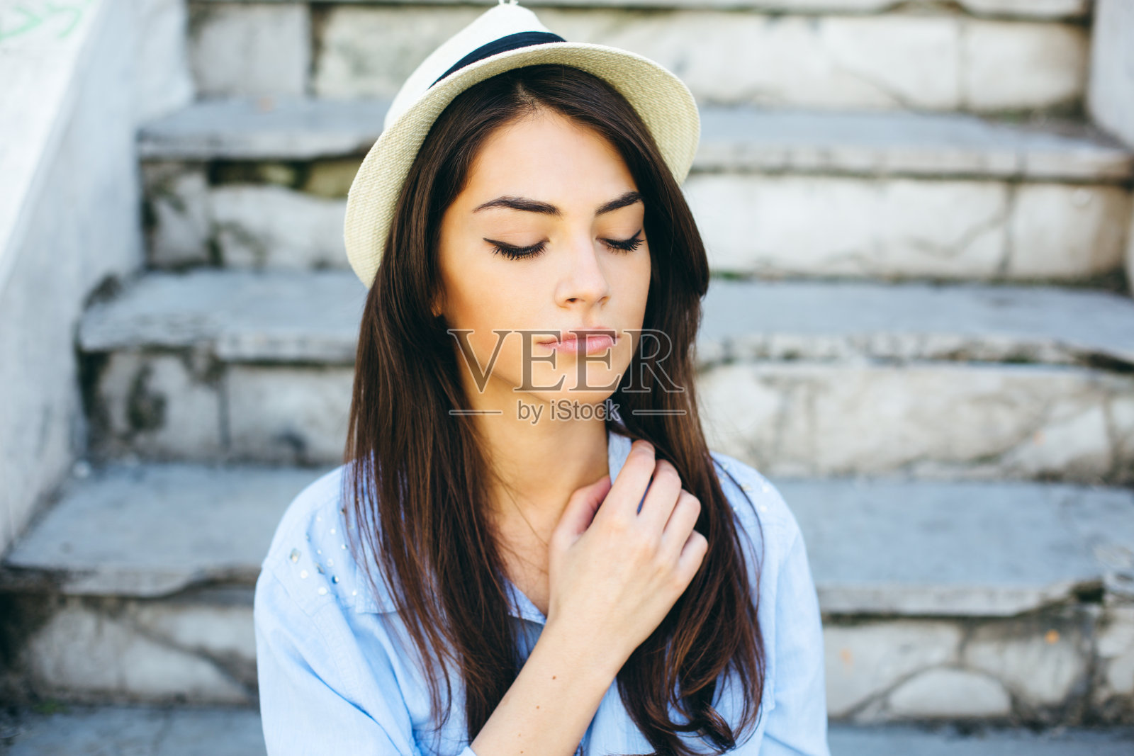 年轻漂亮的女人坐在被毁的楼梯上照片摄影图片