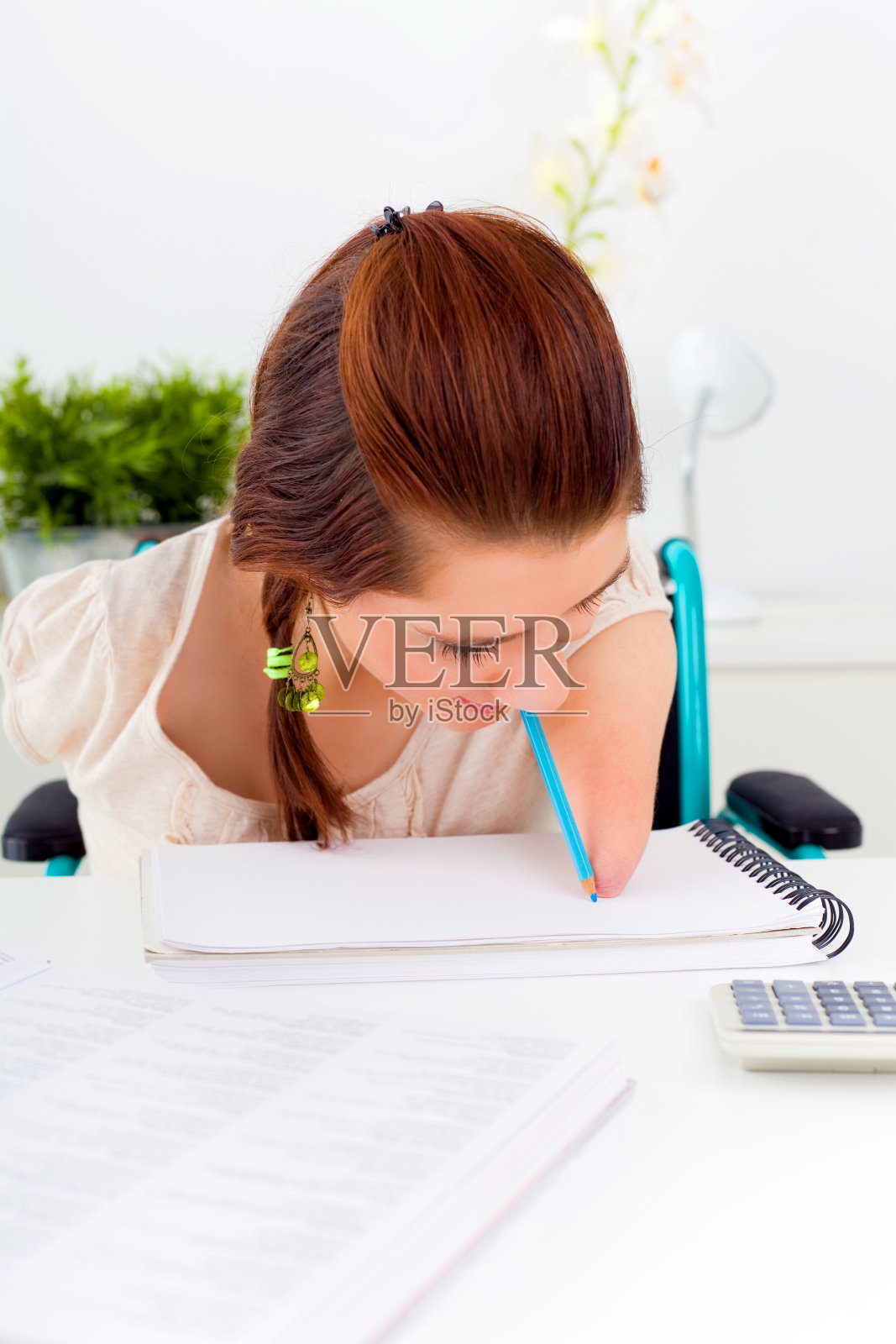 残疾女孩用嘴写字照片摄影图片