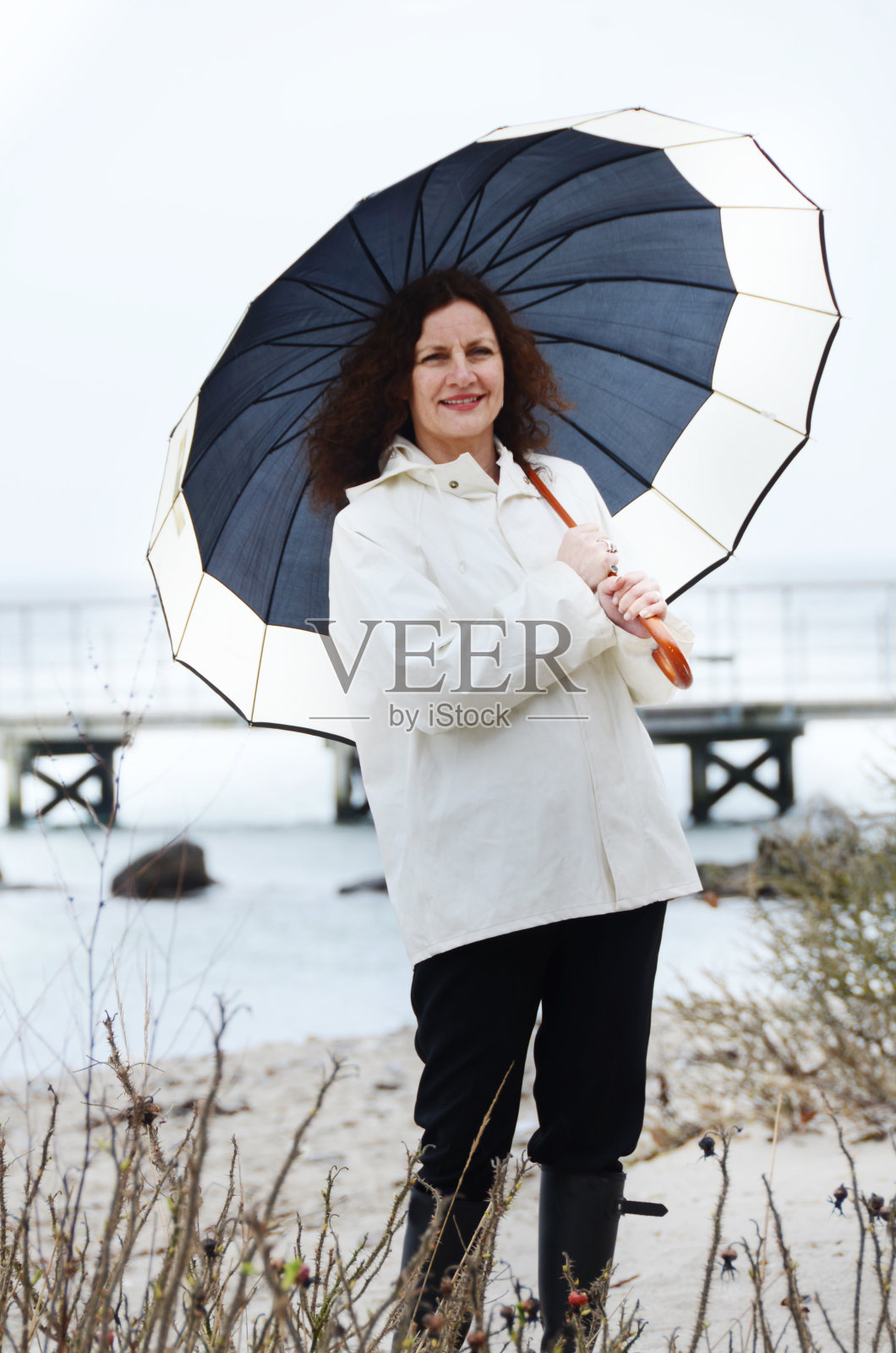 在海滩上拿着伞的女人照片摄影图片