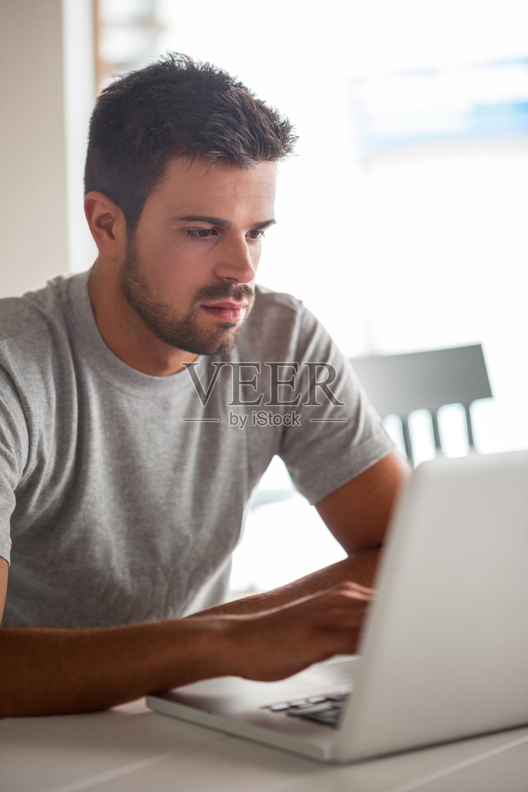 一个年轻人在厨房用笔记本电脑照片摄影图片