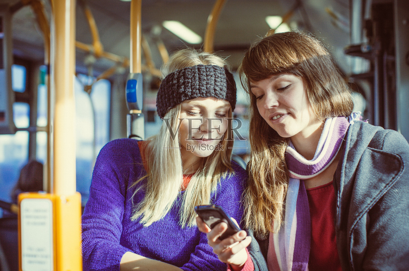 在公交车上拿着智能手机的少女照片摄影图片