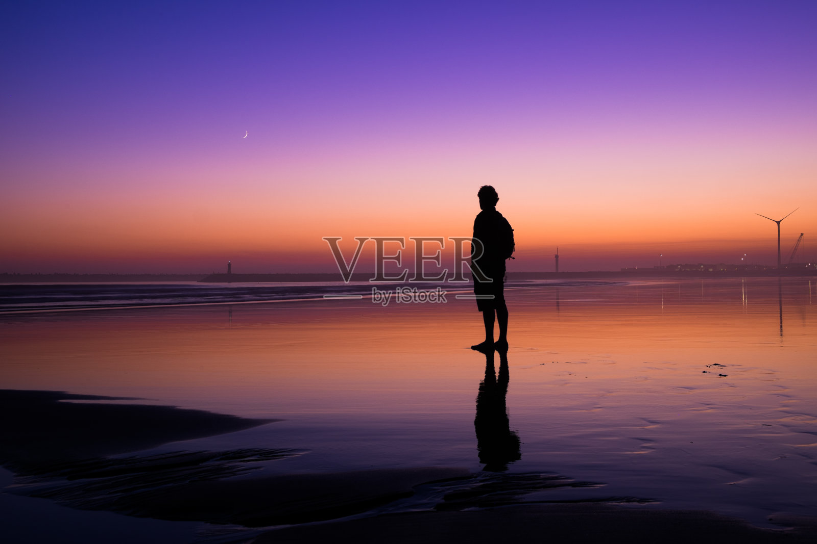 在海滩上看着地平线的人照片摄影图片