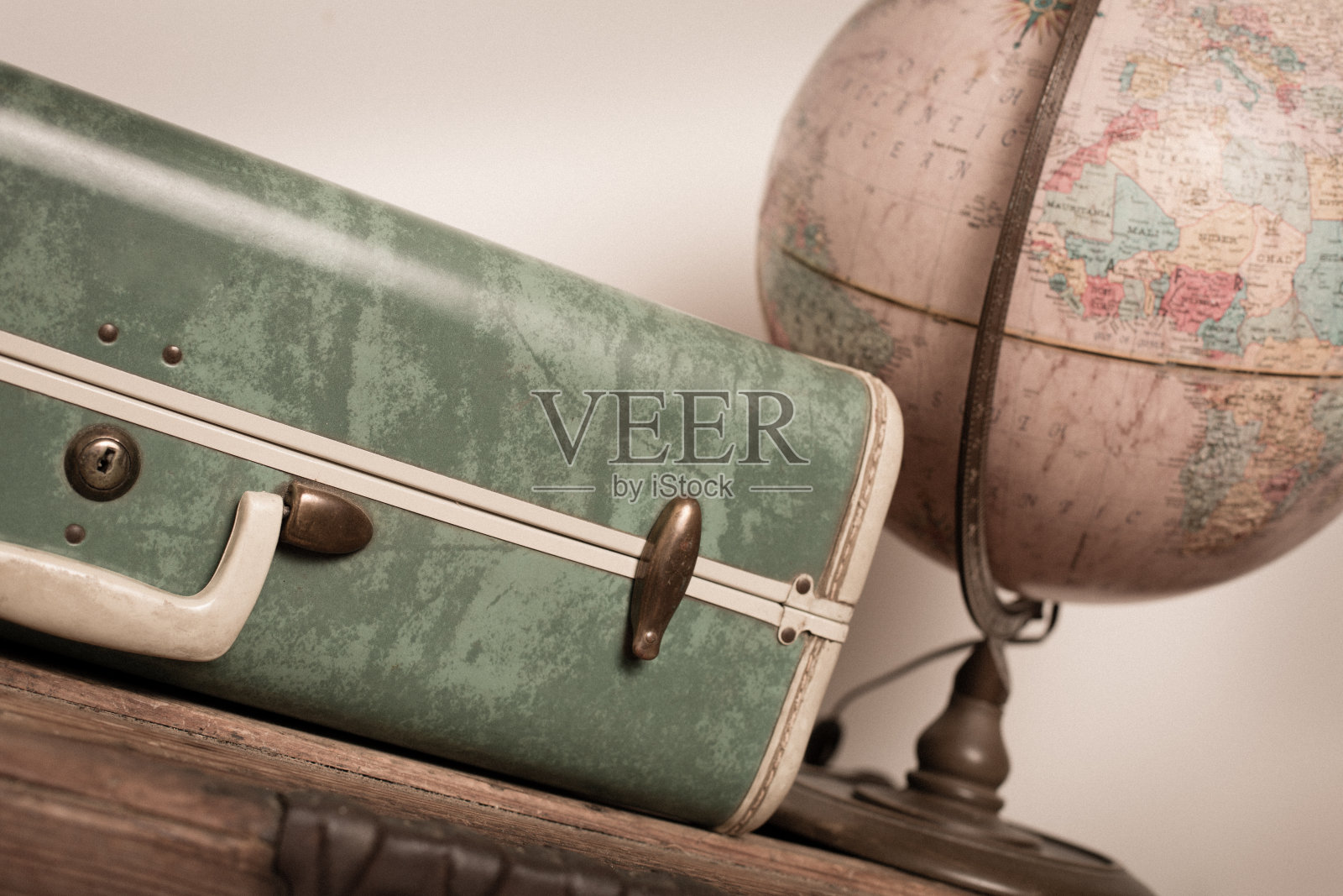 复古绿色旅行箱和地球箱坐在木头箱子照片摄影图片
