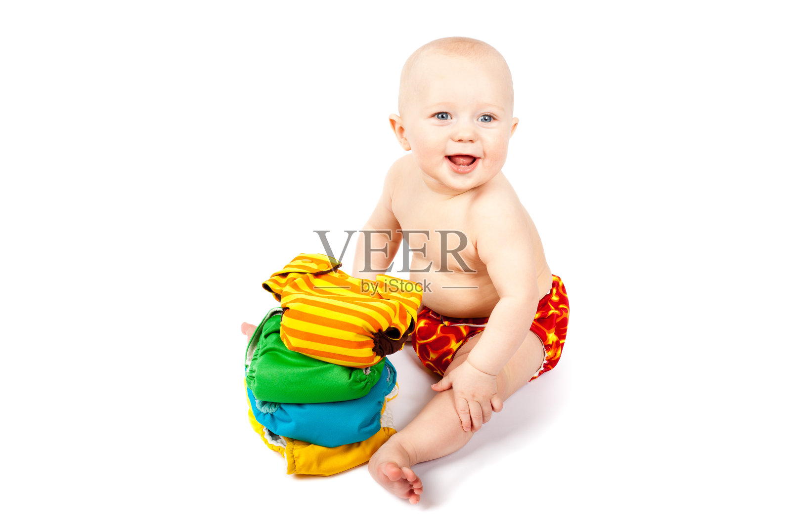 快乐的婴儿坐在一堆五颜六色的布尿布照片摄影图片