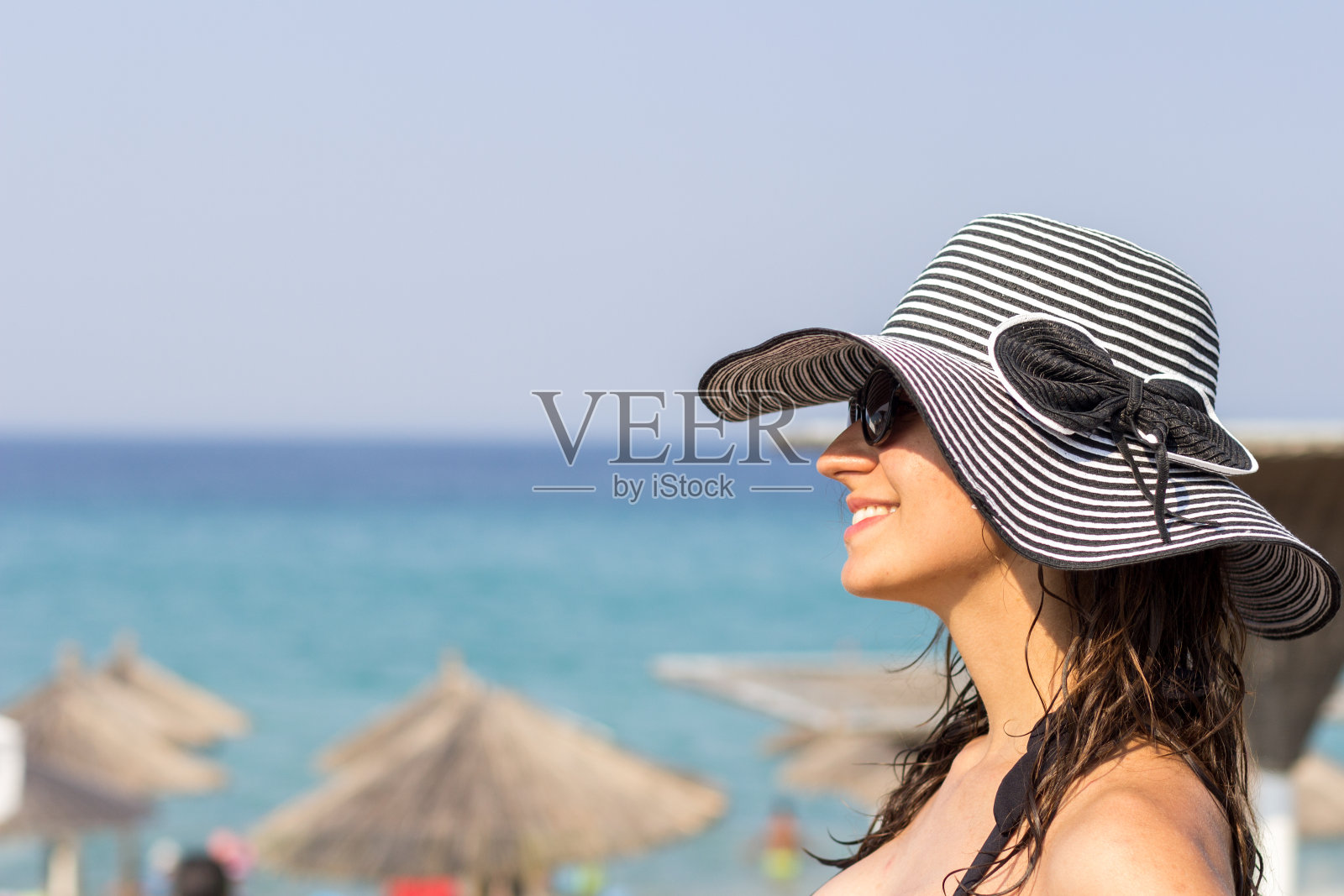 戴着帽子的漂亮女人享受着阳光明媚的日子照片摄影图片