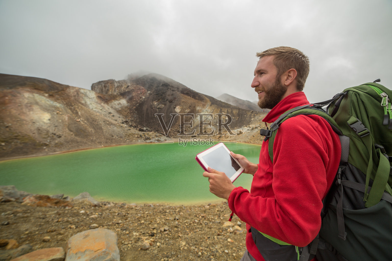 年轻男人新西兰徒步，使用平板电脑照片摄影图片