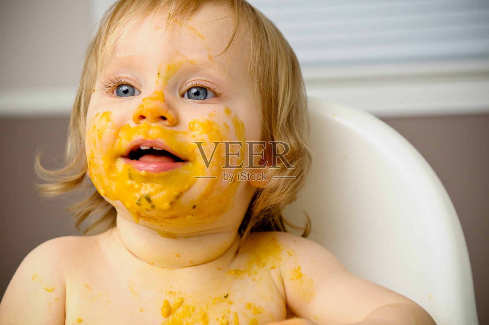 快乐宝宝在高椅子上乱吃食物照片摄影图片