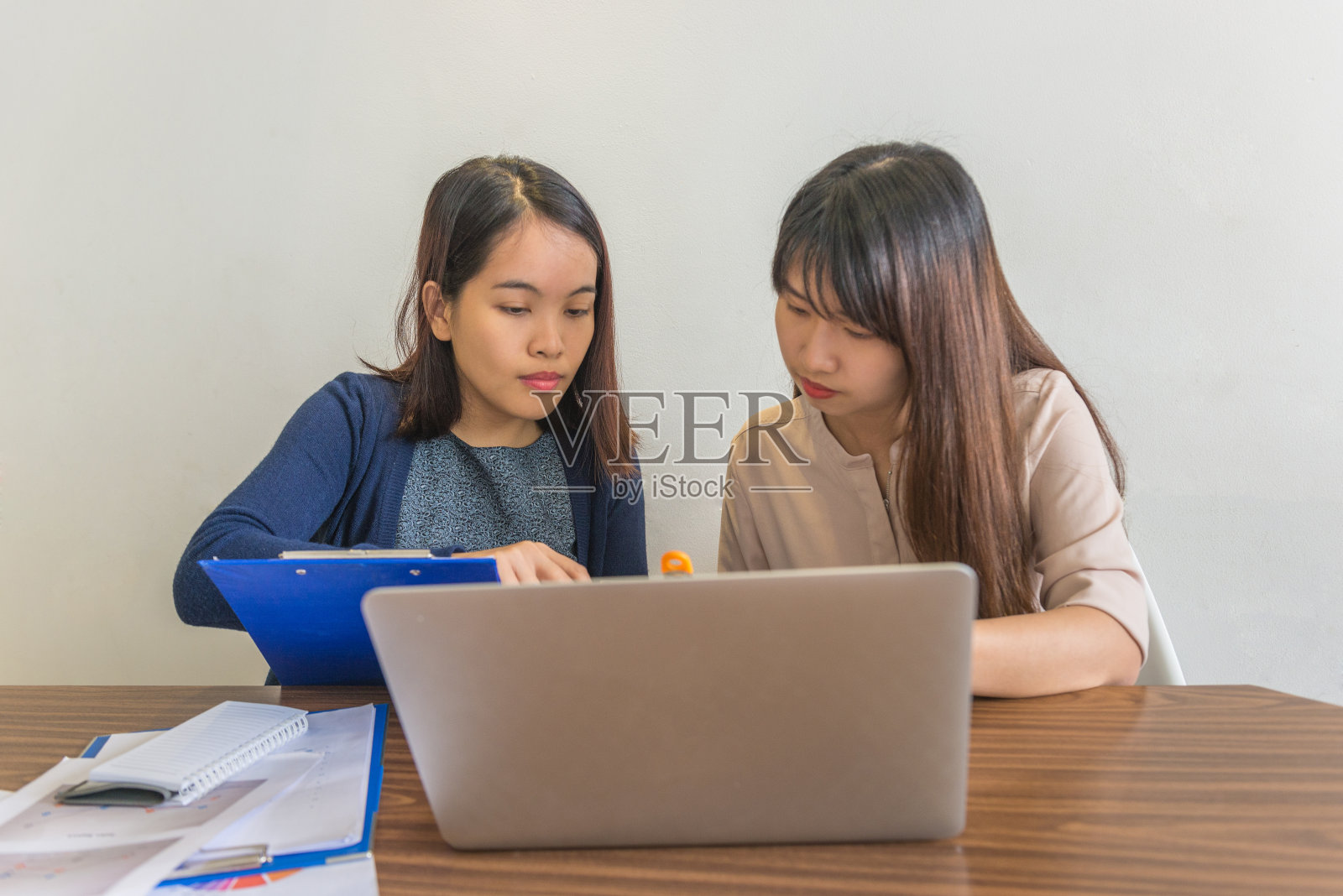 办公室女同事与她的队友讨论销售报告照片摄影图片