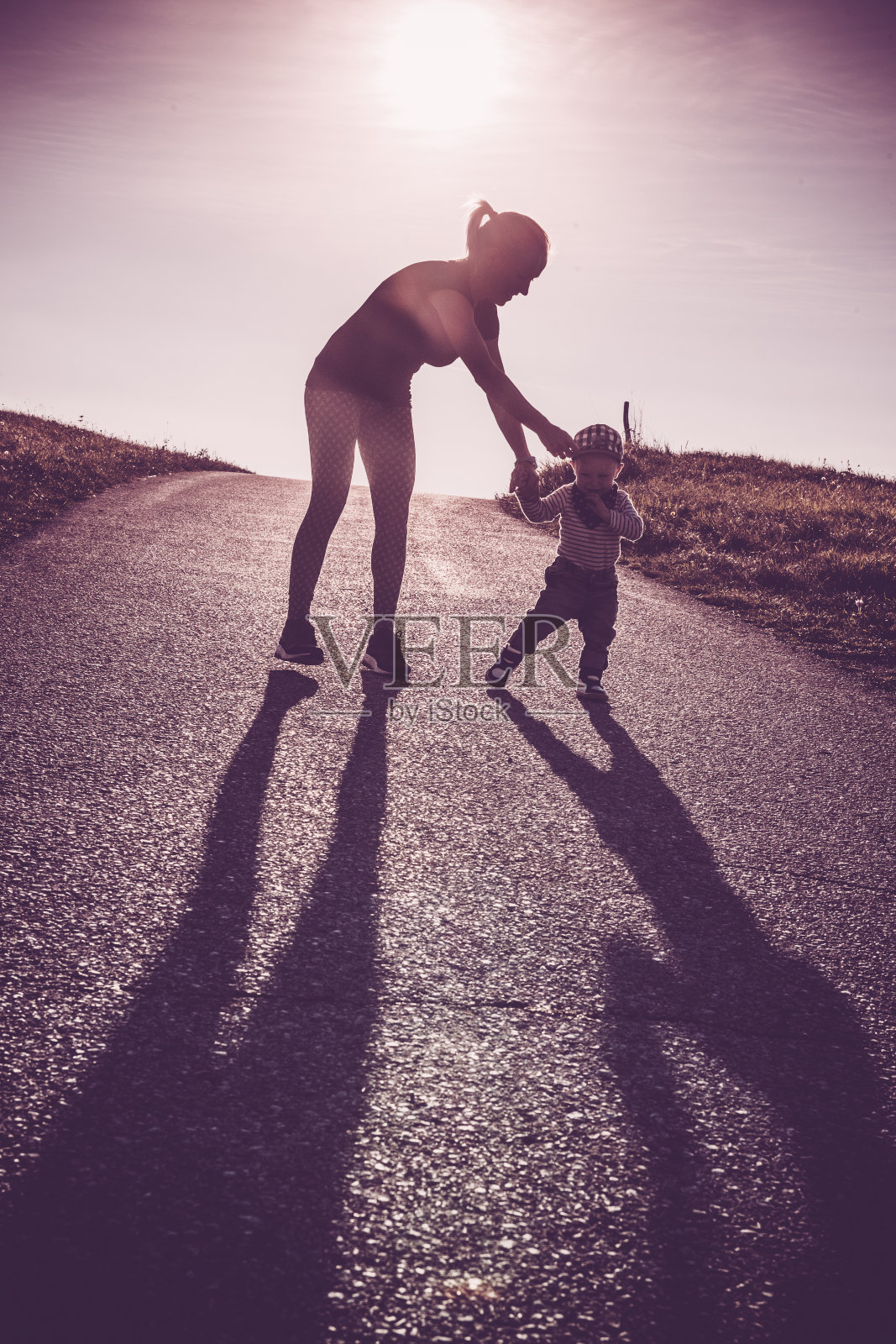 婴儿在父母的帮助下走路——第一步照片摄影图片