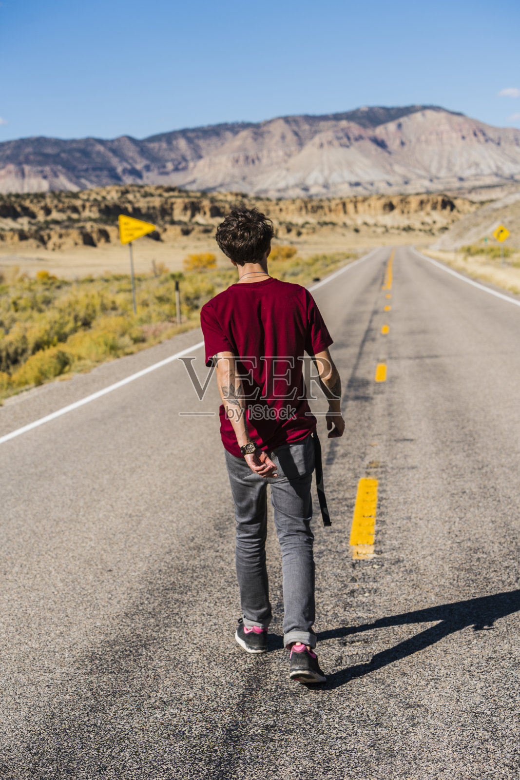 一名年轻游客正走在美国犹他州的高速公路上照片摄影图片