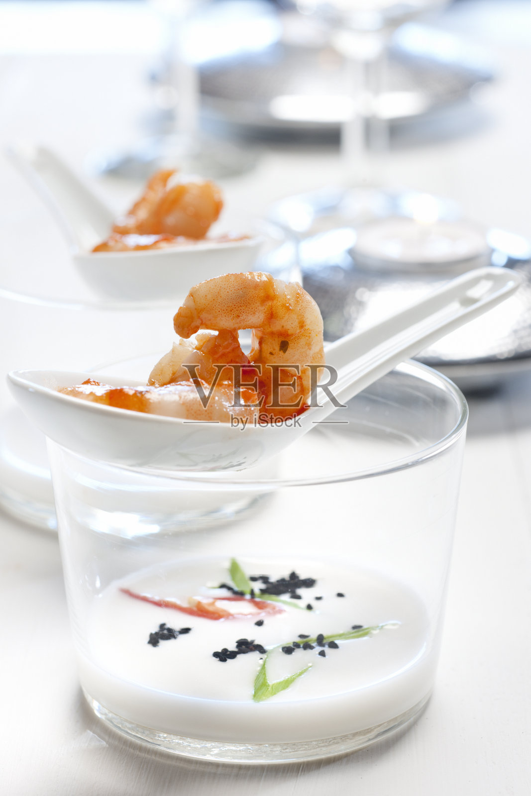 这是一道美味的开胃菜，烤虾配椰奶和辣椒照片摄影图片