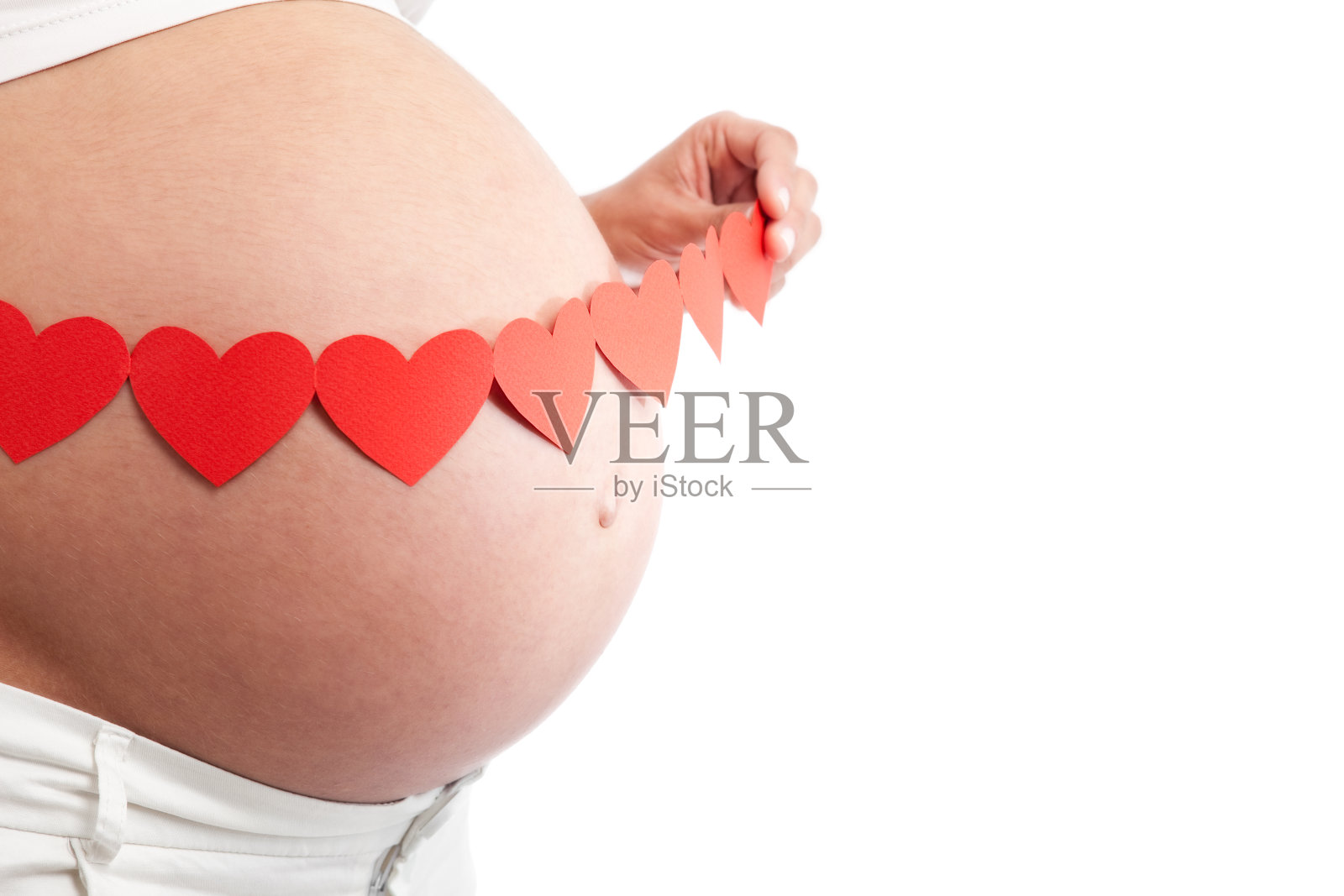 孕妇的肚子上挂着心形的花环照片摄影图片