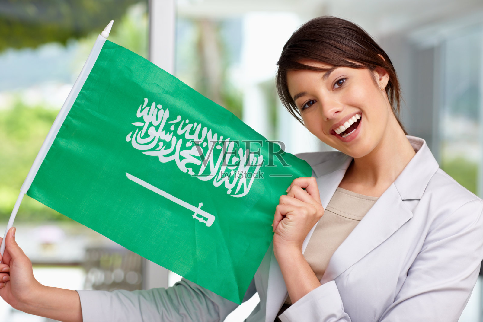 快乐的年轻女子与沙特阿拉伯国旗照片摄影图片