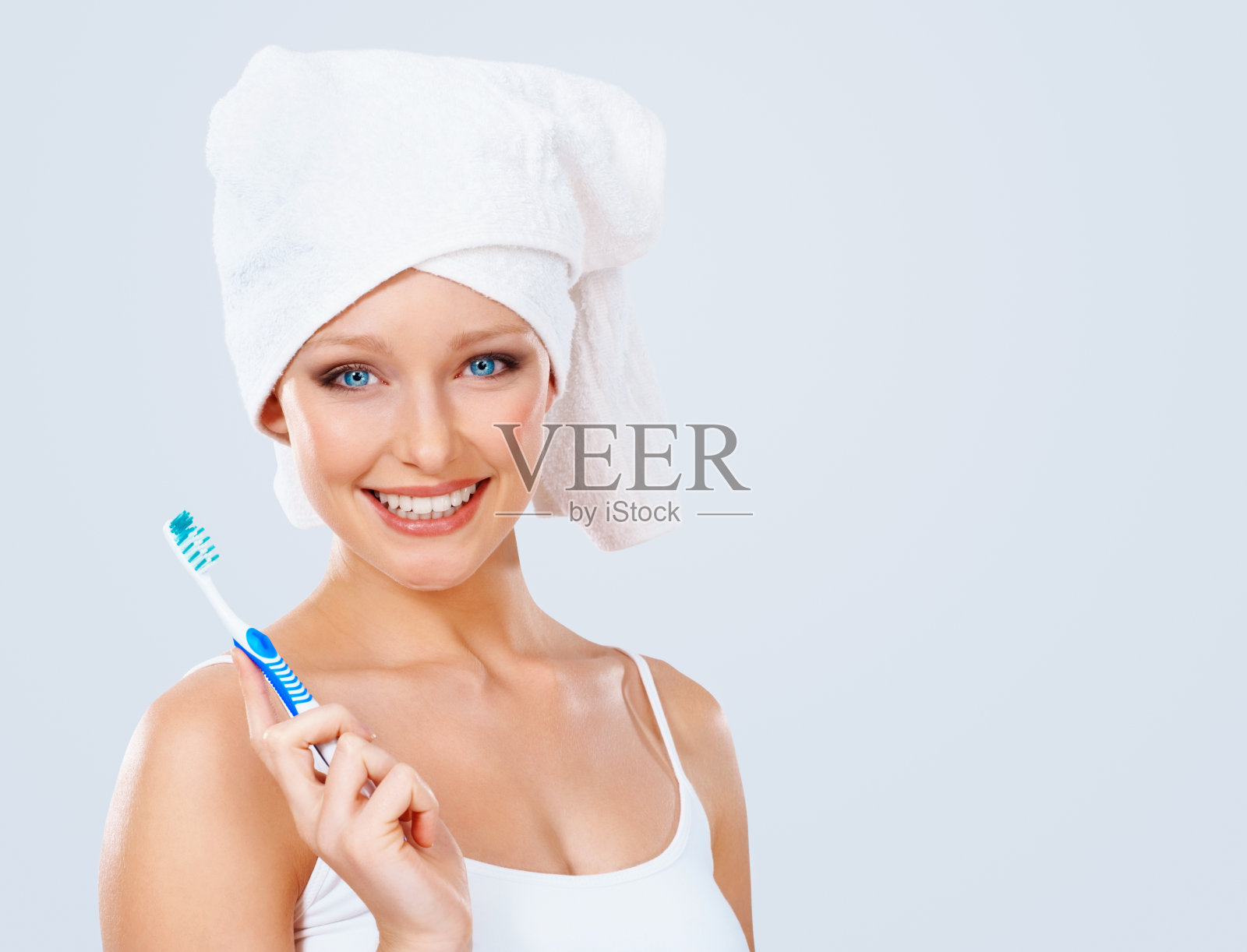 洗完澡后拿着牙刷微笑的漂亮女孩照片摄影图片