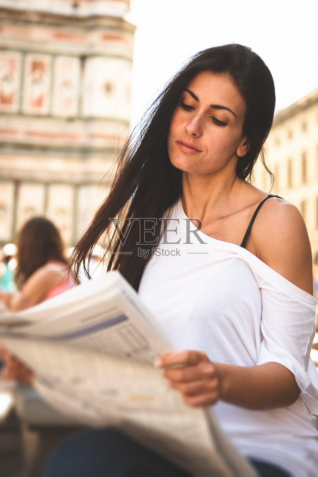 女人在看报纸，面带微笑照片摄影图片