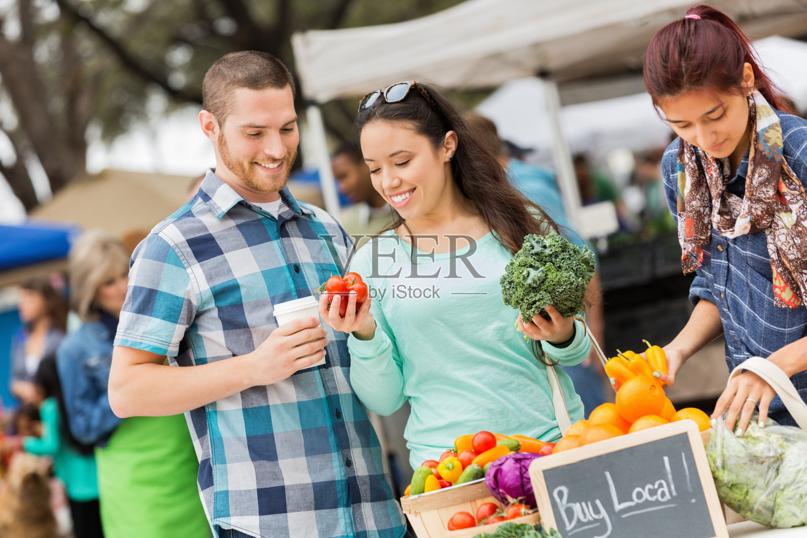 一对快乐的夫妇在繁忙的当地农贸市场购物照片摄影图片