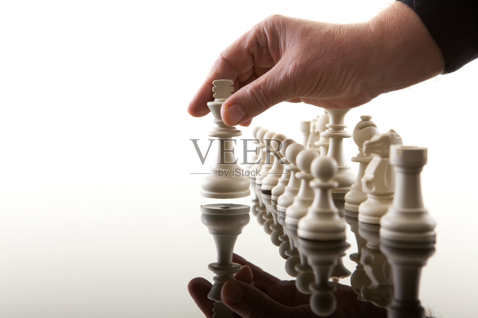 白色背景下手持棋子的特写镜头照片摄影图片