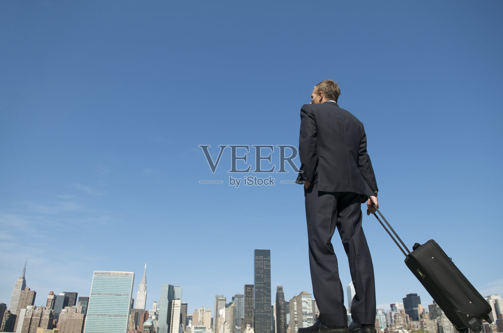 商人站在城市天际线上手提箱照片摄影图片