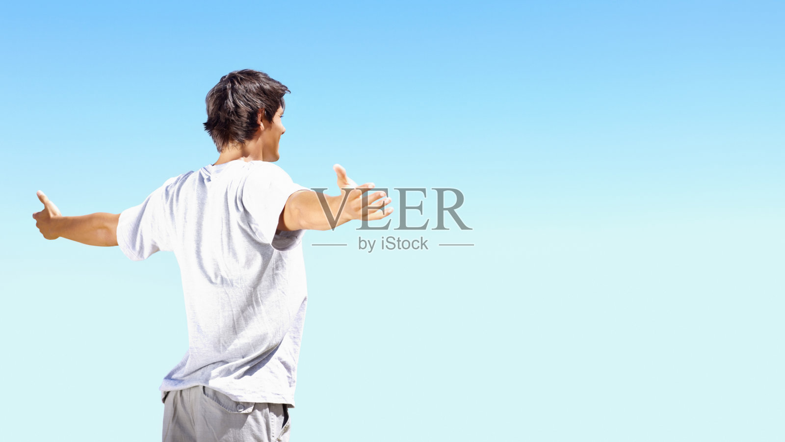 年轻人对着蓝天张开双臂照片摄影图片