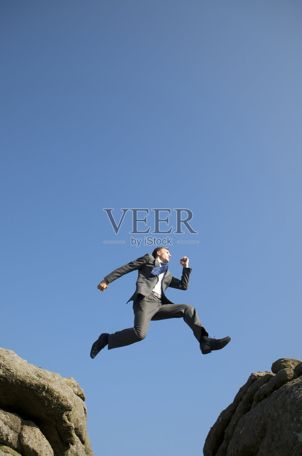 商人在岩石间跳跃照片摄影图片